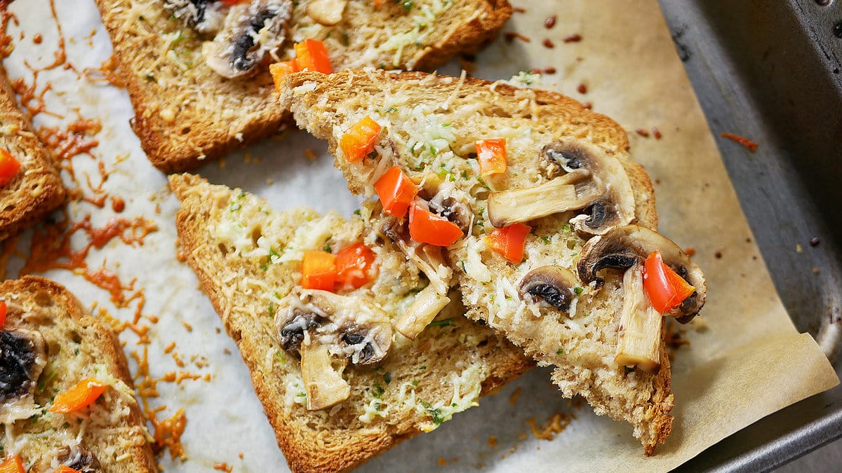 champinjontoast med vitlökssmör på en plåt