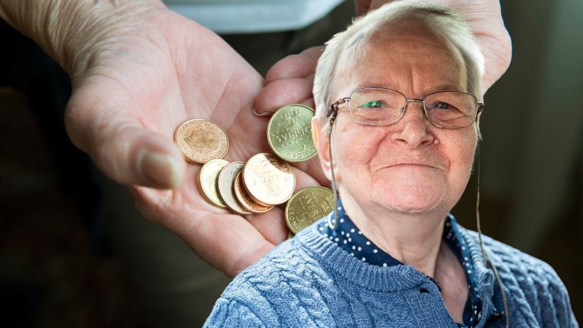 Mynt i en hand och en äldre person.