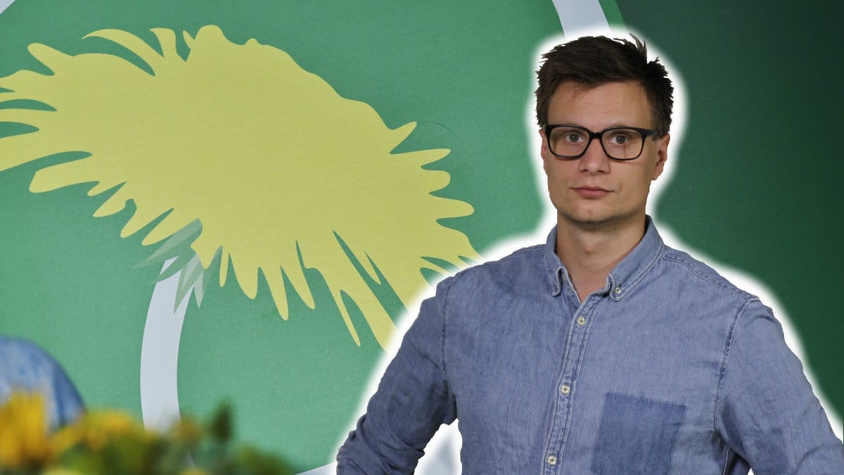 Karl Anders Lindahl framför Miljöpartiets logga