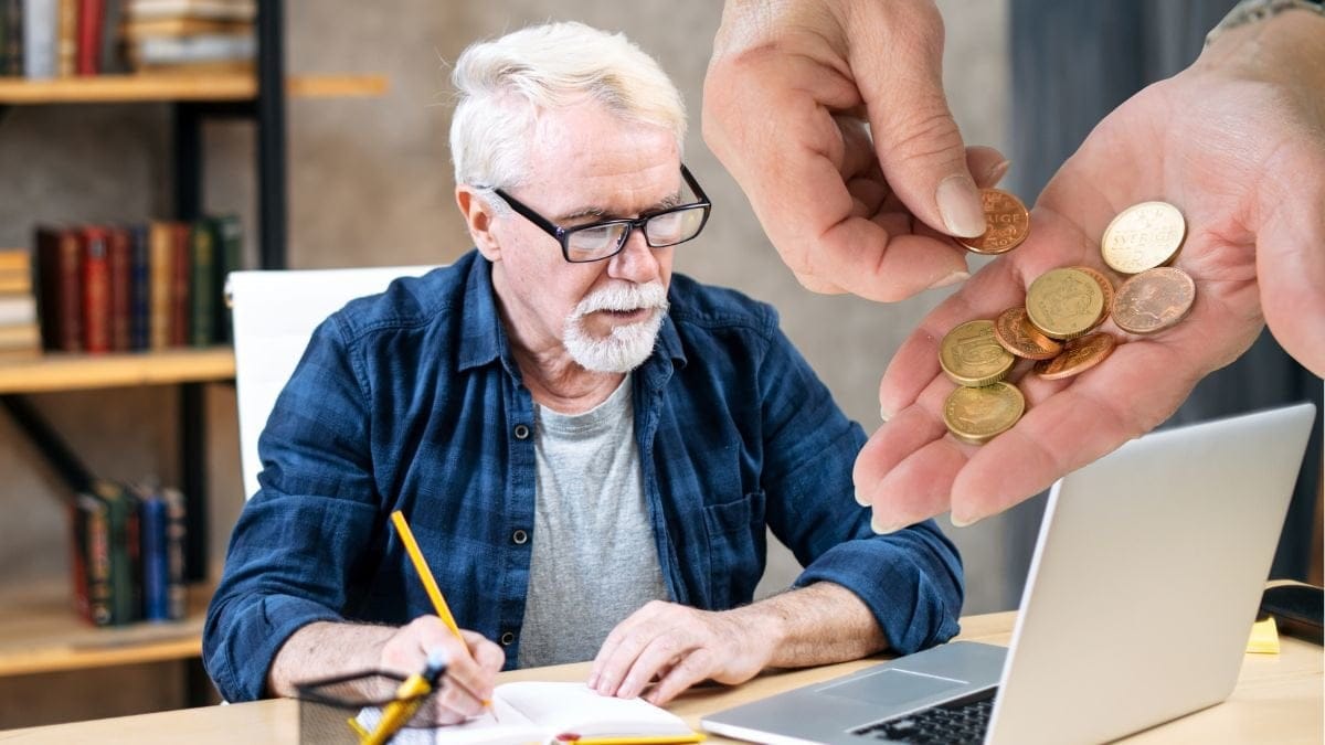 Äldre man som jobbar och en hand med mynt i.