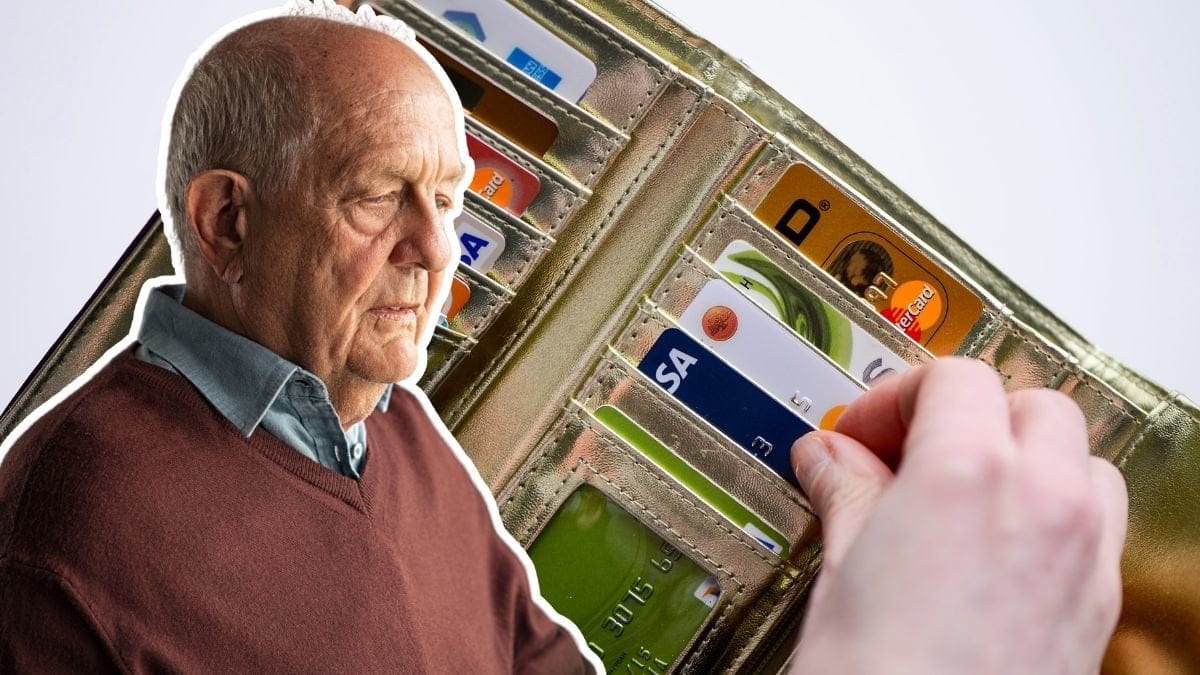 Ledsen man och i bakgrunden syns en plånbok med många olika kontokort.