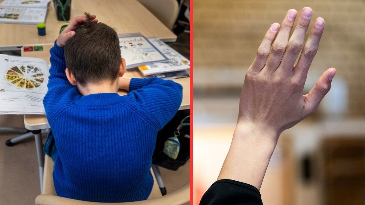 Pojke i skolbänk, elev som räcker upp handen.