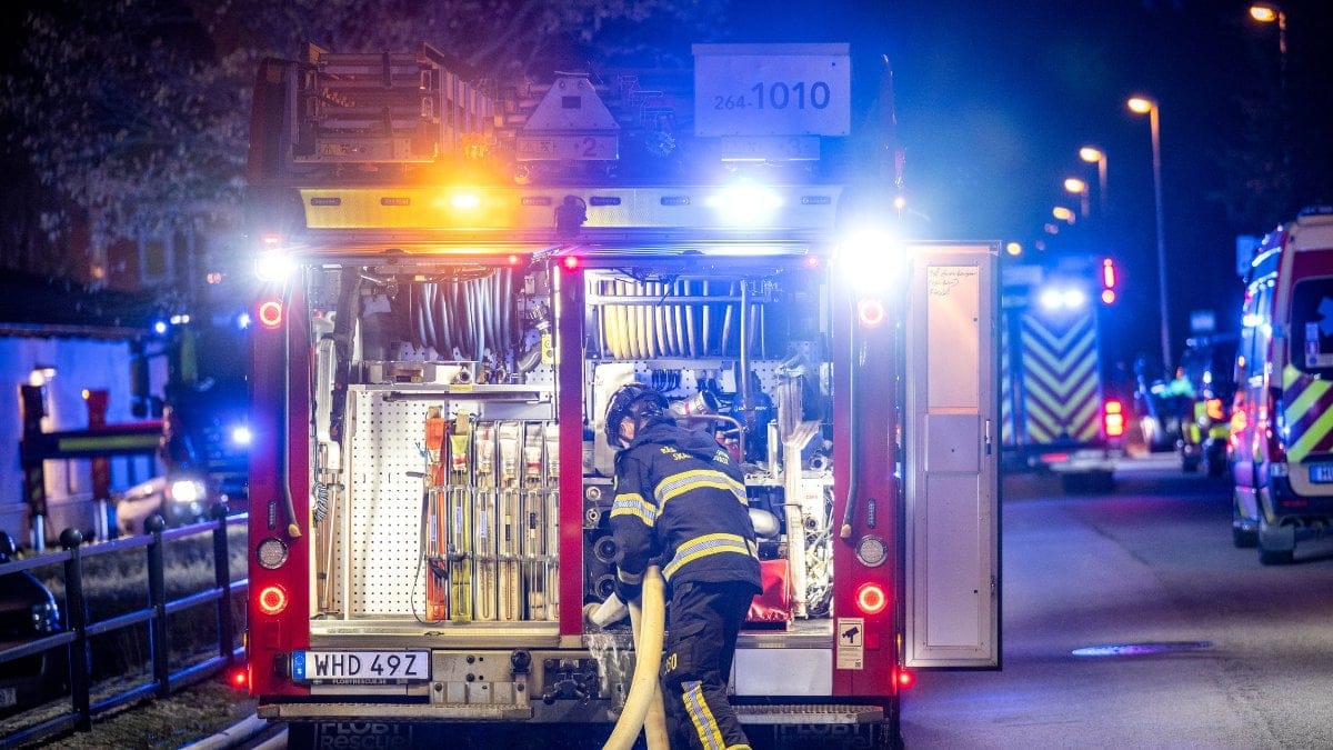 En brandman i baksidan av en brandbil.