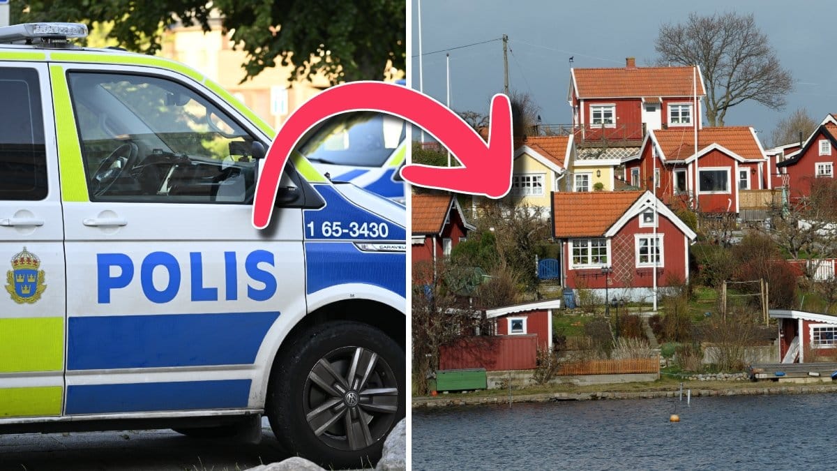 En parkerad polisbil och flera små röda hus vid vattnet.
